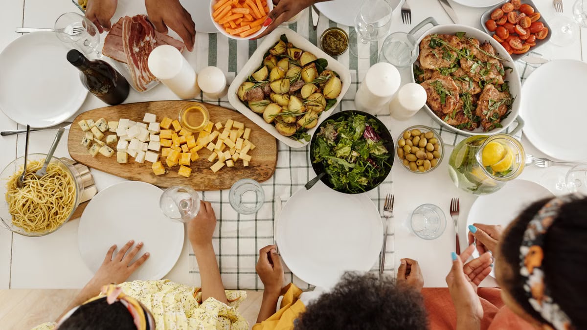 Overhead shot of family enjoying a diverse meal with assorted dishes, olives, and salad.